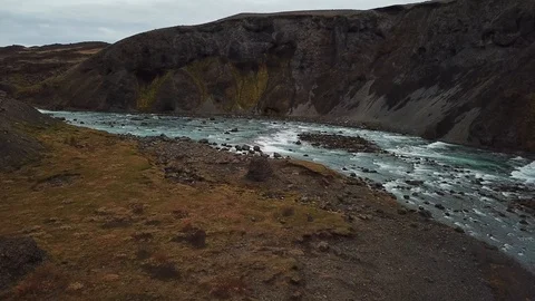 Drone shot of waterfall with blue flowing river amidst rocky landscape Stock Footage