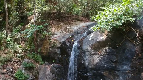 A drone shot of a waterfall at napsan beach, Philippines Stock Footage 109816094