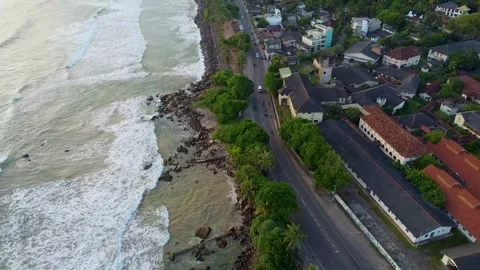 A drone shot of waves on the beach and a city visible on one side. Stock Footage 305523639