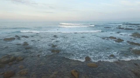 Drone shot of waves breaking on rocky shore Stock Footage
