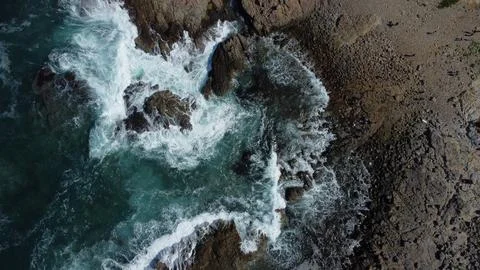 Drone shot of the waves hitting the Rocks Stock Photos