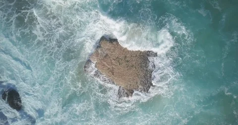 Drone shot of waves splashing on the rocks in the sea Stock Footage 122380029