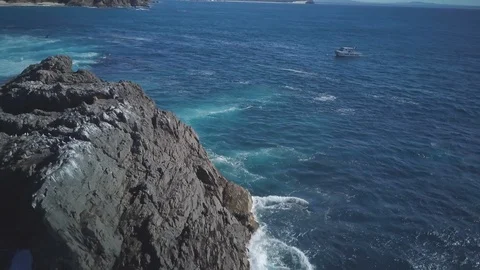 Drone shot of waves splashing on rocks at seaside Video stock 122485266