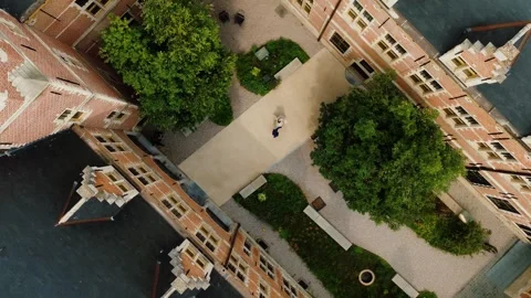 Drone shot of wedding couple dancing in historic Belgian castle courtyard Stock Footage 306355175