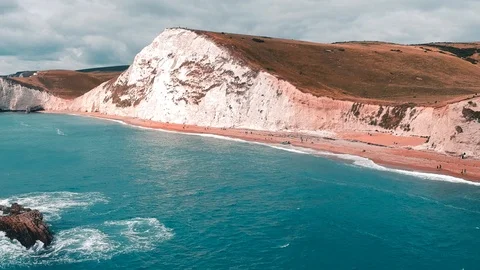 Drone shot of the white cliffs of Durdle door beach, along English coastline Stock Footage 107242901