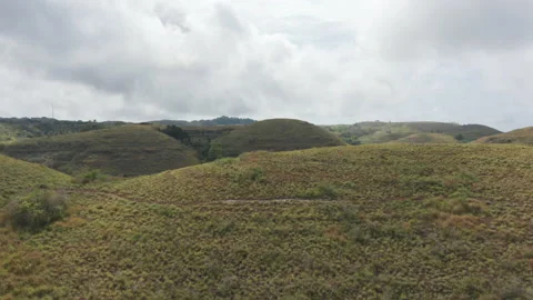 Drone Shot of White Clouds and Tropical Savannah Hills in Bali, Indonesia Stock Footage 133825503
