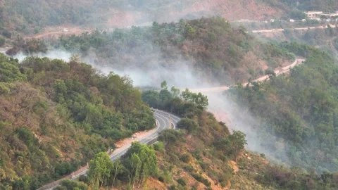 Drone shot of wildfire smoke over national highway in India. Climate change  Stock Footage 335640099