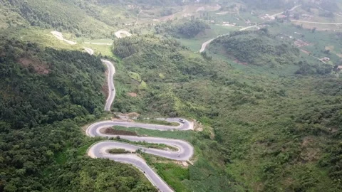 Drone shot of winding road surrounded by forest and jungle near Ma Pi Leng Pass Stock Footage 144910032