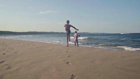 Drone shot of a young boy running to his father on the beach Stock Footage 254797406