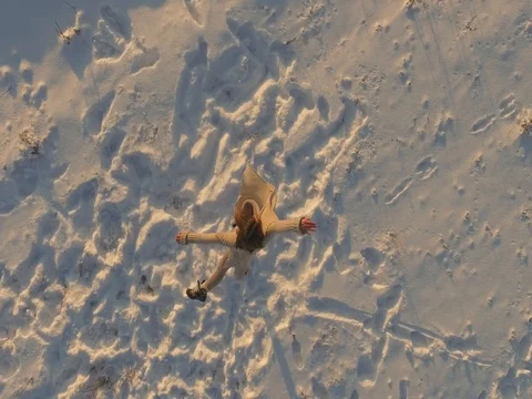 Drone shot of a young lady dancing in snow covered field Vídeos de archivo 74177363