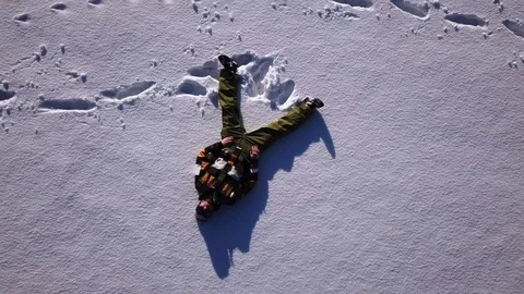 Drone shot of a young man with ski suit laying alone in a wide open snow 스톡 동영상 105384596
