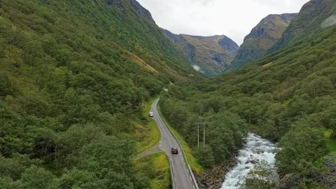 Drone shows car gliding through lush valley road in Norway. Stock Footage 321002747