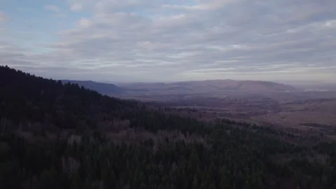 Drone Side Flight Over Forested Mountain Landscape With Distant City Stock Footage 327205045