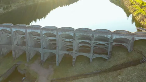 Drone side flyby along concrete dam with reflection, cinematic aerial tracking s Stock-Footage 333070244