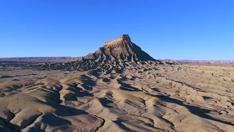 Drone Side-Scroll of Eroded Shale Ridges and a Massive Monolith in the Utah Stock Footage 330913347