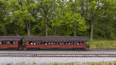 Drone Side View of an Antique Open Air Passenger Coach, With Passengers Waving Stock Photos