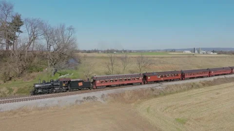 Drone Side View of a Antique Steam Passenger Train Blowing Smoke, Traveling.. Stock Footage 235960244