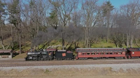 Drone Side View of a Antique Steam Passenger Train Blowing Smoke, Traveling.. Stock Footage 235960261