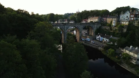 Drone sideways reveal behind forest trees to show large historic stone viaduct Stock-Footage 321440234