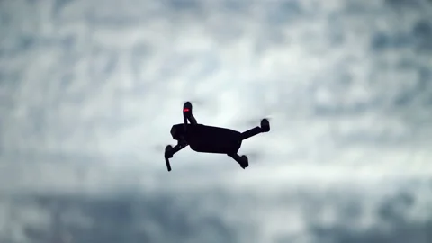 Drone Silhouette Flying on Cloudy Sky Stock Footage 133432206