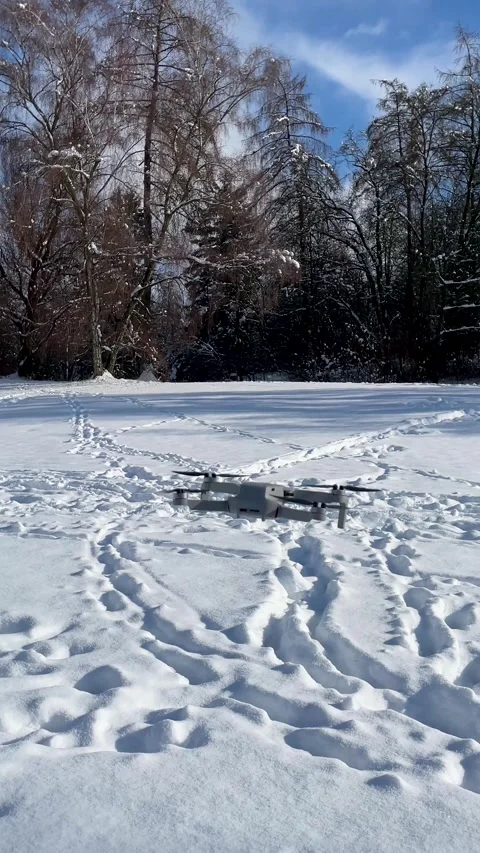Drone Sits in Snow With Footprints Around at a Park on a Sunny Winter Day Stock Footage 327908845