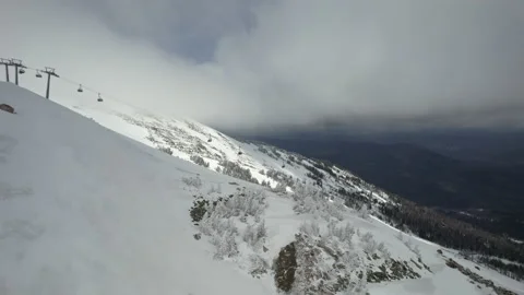 Drone ski lift moving through clouds in winter resort Stock Footage 180052953