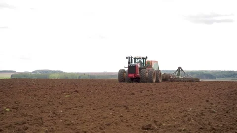 Drone sliding shot of a farmer in tractor seeding, sowing agricultural Stock Footage 132583418
