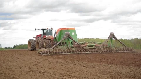 Drone sliding shot of a farmer in tractor seeding, sowing agricultural Stock Footage 132583433