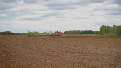 Drone sliding shot of a farmer in tractor seeding, sowing agricultural Stock Footage 132584487