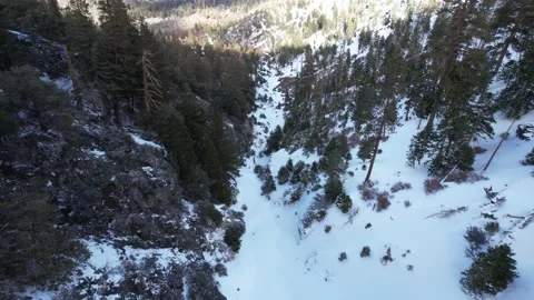 Drone sloping down snow covered draw in mountain Stock Footage 172264854