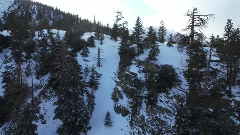 Drone sloping up to snow capped mountain overlook Stock Footage 172264358