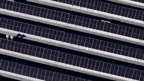 Drone slow ascent over rooftop solar panels in repeating diagonal pattern for Видео 328998924