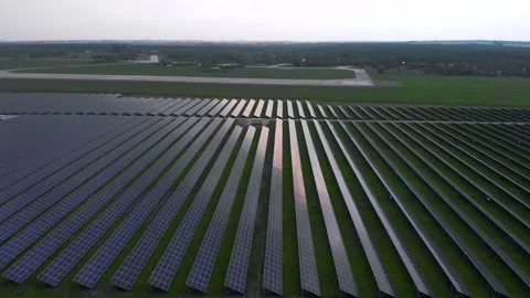 Drone slow flies into large solar panels at a solar farm at cloudy summer Stock Footage 132651217