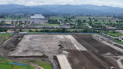 Drone slow pullback above datacenter construction site with Frecciarossa train Stock-Footage 336663542