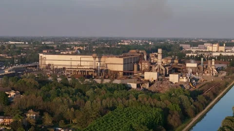 Drone slow pullback from Acciaieria Arvedi steel plant along Canale Milano Stock Footage 334717410