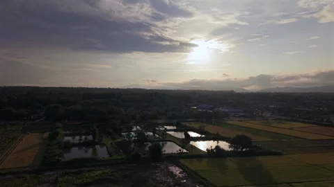 Drone slow push over countryside ponds reflecting a bright dramatic sunset sky 스톡 동영상 335763597