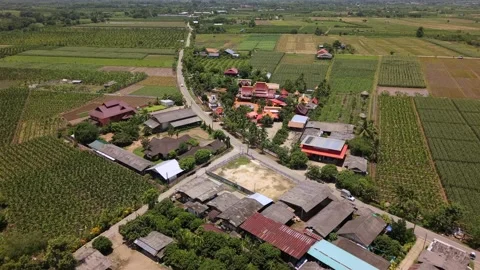 Drone slow push in over rural village houses approaching a colorful temple Video stock 335806144