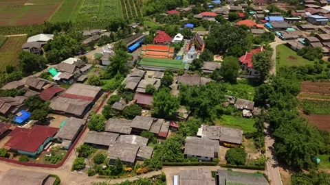 Drone slow push in over a traditional rural village and temple in Thailand Stock Footage 335806119