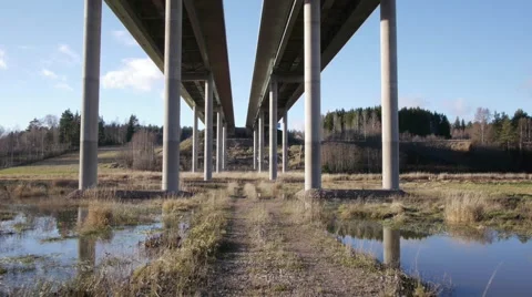 Drone slow tracking shot flight under the bridge in sun set Stock Footage 44903621