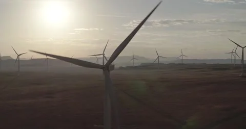 Drone slowly Approaching Backlit Wind Turbine just after sunrise in South Africa Stock Footage 243765035