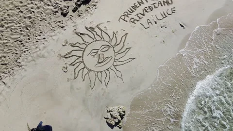 Drone Slowly Ascending Away From Men Drawing On The Beach Stock Footage 152126983