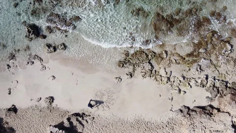 Drone Slowly Ascending Away From Men Drawing On The Beach (sand) Stock Footage 153247332