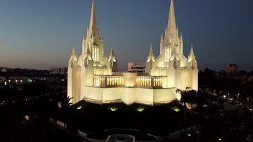 Drone slowly ascends from bottom of the Mormon Temple to the top after sunset Stock Footage 86132442