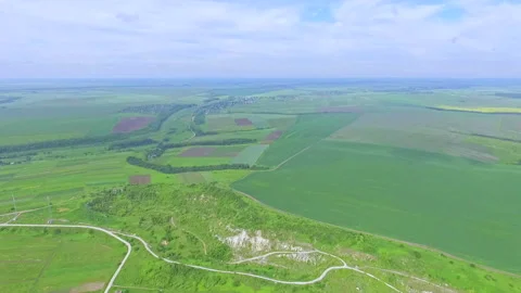 The drone slowly climbs above the fields and ravines. View from above. Green 動画素材 94779136