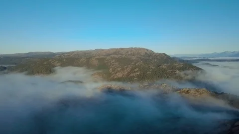 Drone slowly decreasing altitude going down and into mist. Mountains and Stock Footage 98923534