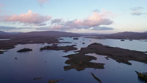 A drone slowly descends towards a patchwork landscape of islands amongst Video stock 221393886