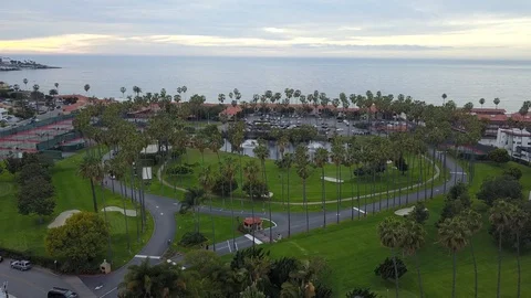 Drone slowly flies backwards over palm tree filled golf course in California Stock Footage 87958912