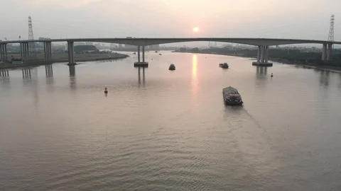 A drone slowly flies over a river along which many cargo ships sail. Stock Footage 114126746