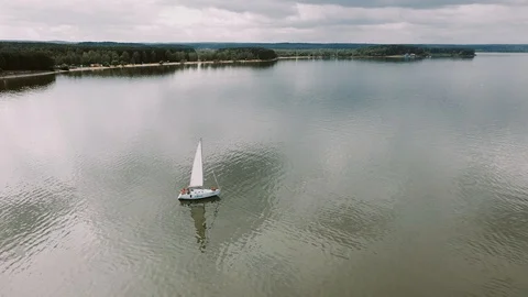 The drone slowly flies over a sailing boat in the lake Stock Footage 117445265
