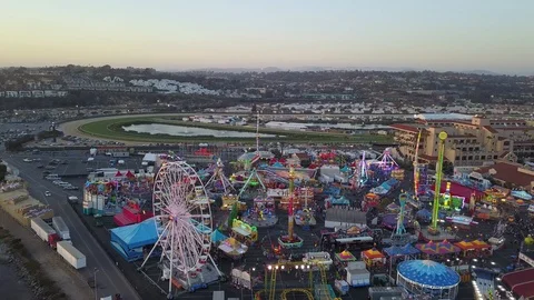Drone slowly fly over fair carnival rides and midway amusements in late day 库存影片 98268149